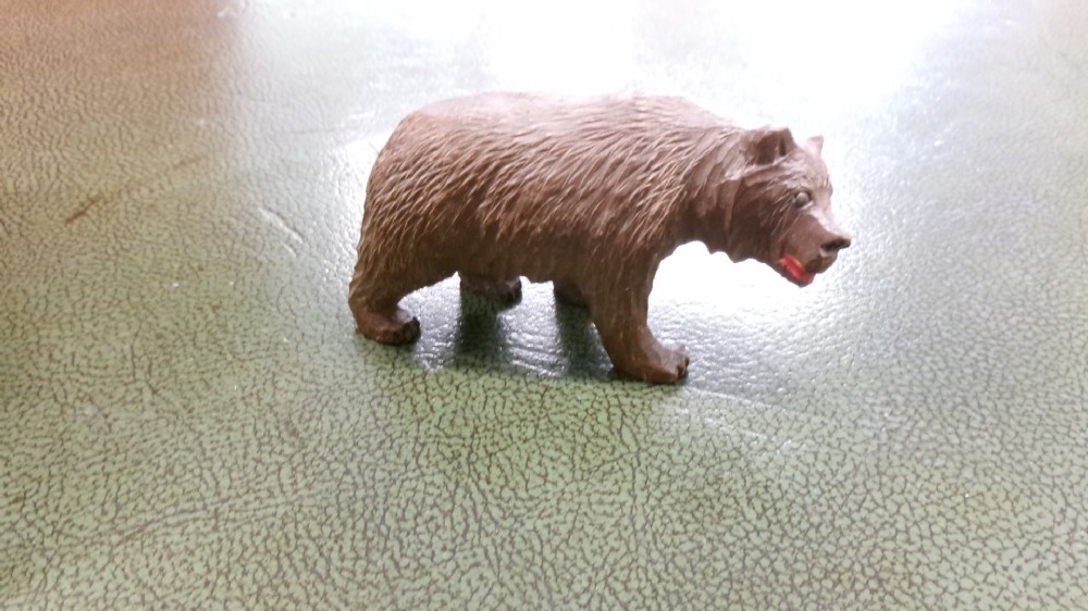 A hand-carved brown wooden bear figurine featuring textured fur, stud eyes, and an open painted red mouth. View II