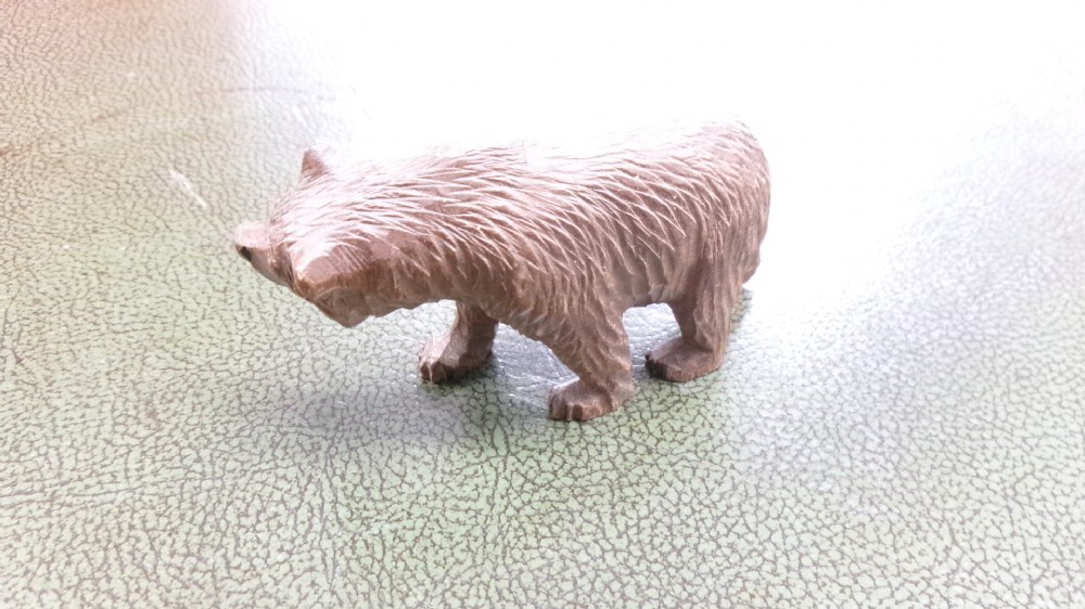 A hand-carved brown wooden bear figurine featuring textured fur, stud eyes, and an open painted red mouth. View IV