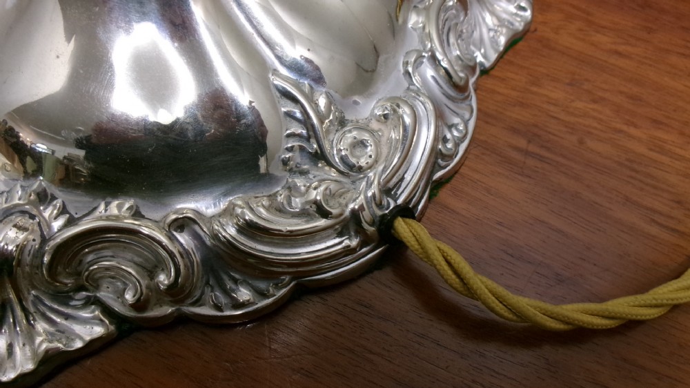 An Edwardian silver-plated table lamp base featuring Rococo scrollwork, a shaped baluster stem, and a moulded plinth base. View V