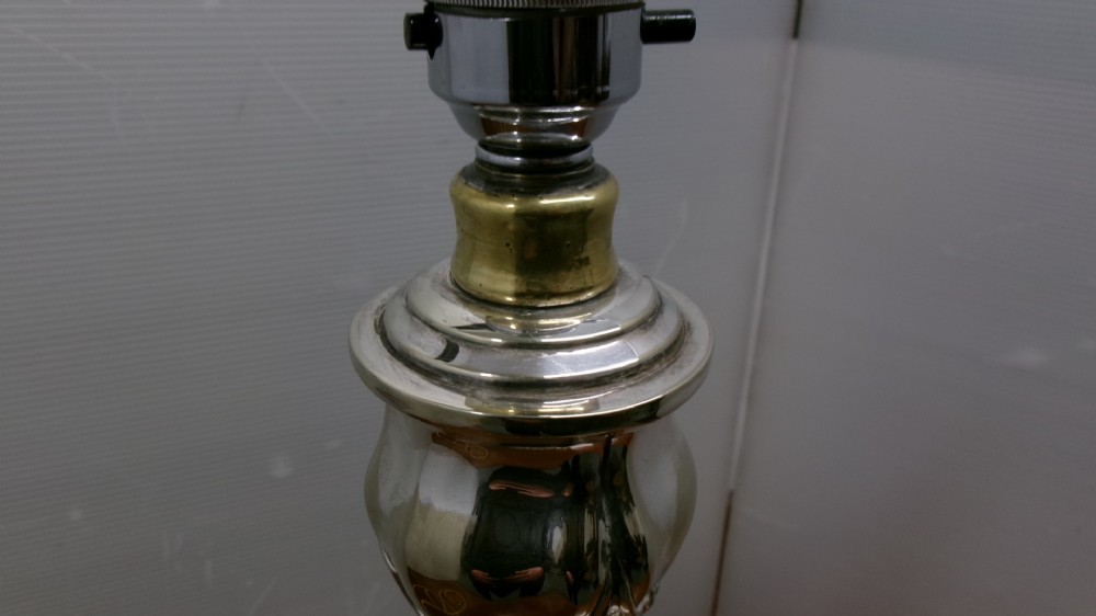 An Edwardian silver-plated table lamp base featuring Rococo scrollwork, a shaped baluster stem, and a moulded plinth base. View VIII