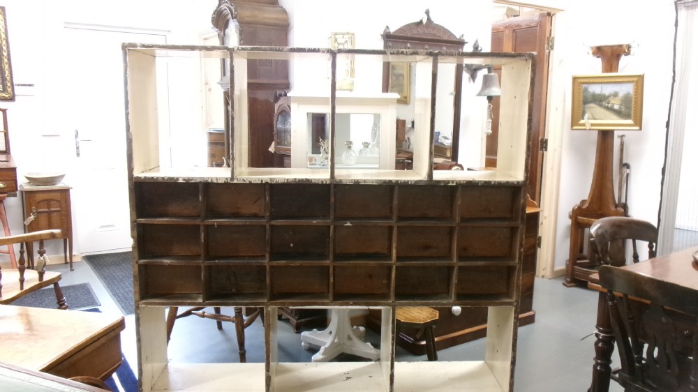 A pair of large Victorian painted shop fitting units featuring open cubby shelves and multiple dark wood drawers with round knobs. View IV