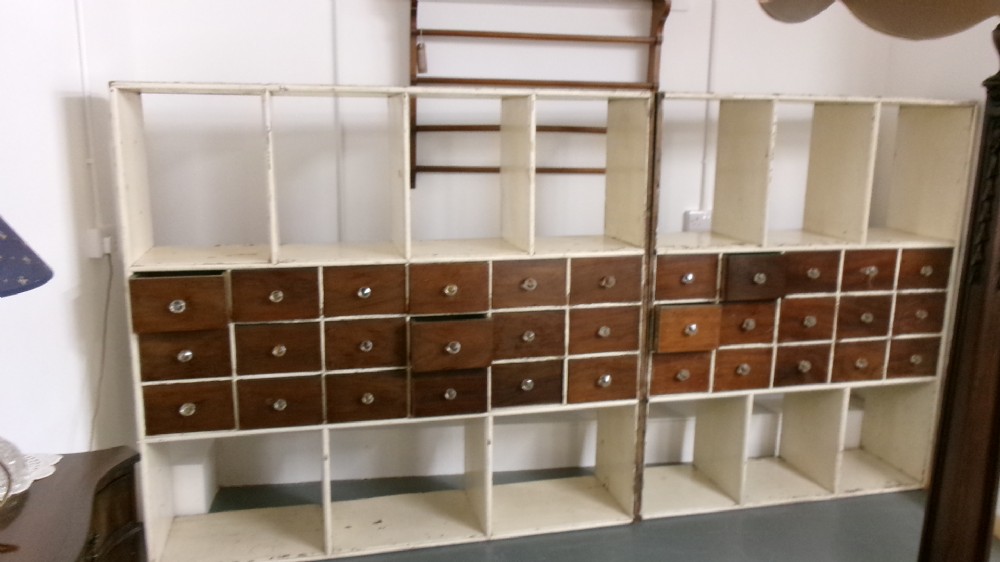 A pair of large Victorian painted shop fitting units featuring open cubby shelves and multiple dark wood drawers with round knobs. View XII