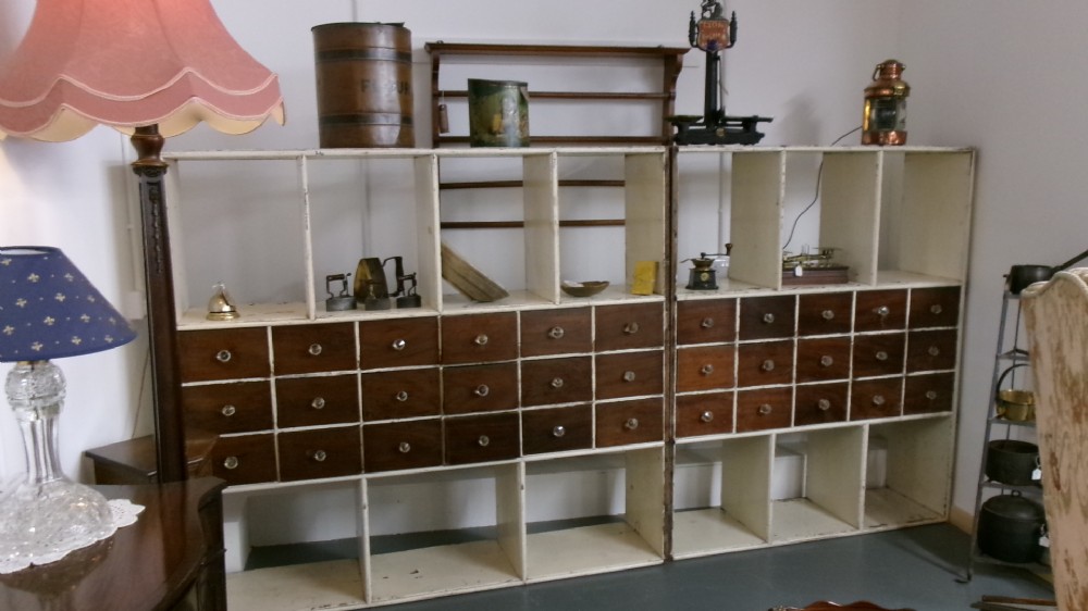 A pair of large Victorian painted shop fitting units featuring open cubby shelves and multiple dark wood drawers with round knobs. View XIII