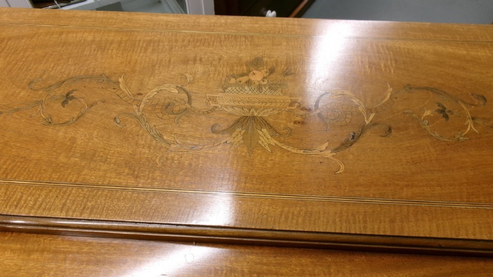 An antique Edwardian inlaid mahogany cylinder top writing desk featuring an open curved roll top, fitted internal compartments, a green leather writing surface, and tapered square legs with brass castors. View VIII