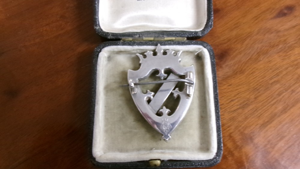 A Victorian silver shield-shaped brooch inlaid with pink and grey agate stones and set with faceted citrines and a central cabochon gemstone. View IV