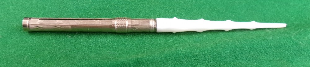 A Victorian Mabie Todd & Co gold-plated dip pen featuring an engraved metal barrel, metal nib, and a carved white handle. View IV