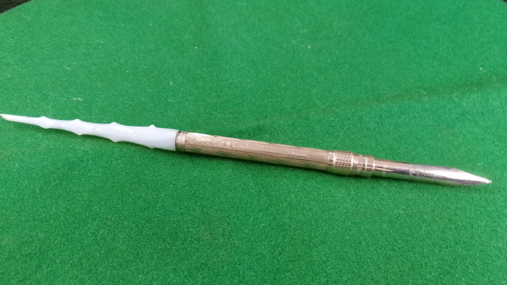 A Victorian Mabie Todd & Co gold-plated dip pen featuring an engraved metal barrel, metal nib, and a carved white handle. View VII