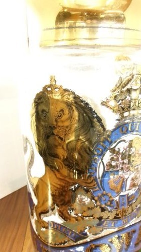 A large clear glass Victorian apothecary jar featuring a gilded coat of arms and arrowroot inscription topped with a fitted domed brass lid. View X