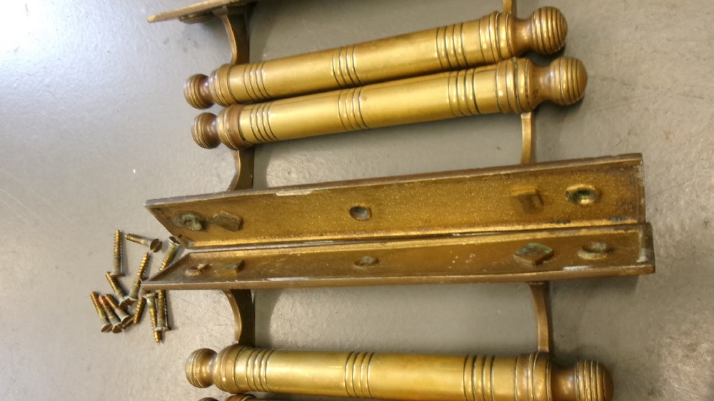 Two pairs of Arts and Crafts brass pull door handles featuring rectangular backplates with incised geometric line detailing and turned cylindrical bar grips with spherical finials. View XIII