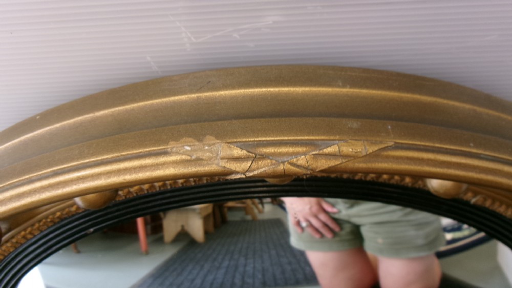 A circular Victorian giltwood convex mirror featuring a ball-decorated outer frame and a black ebonised inner slip. View VI