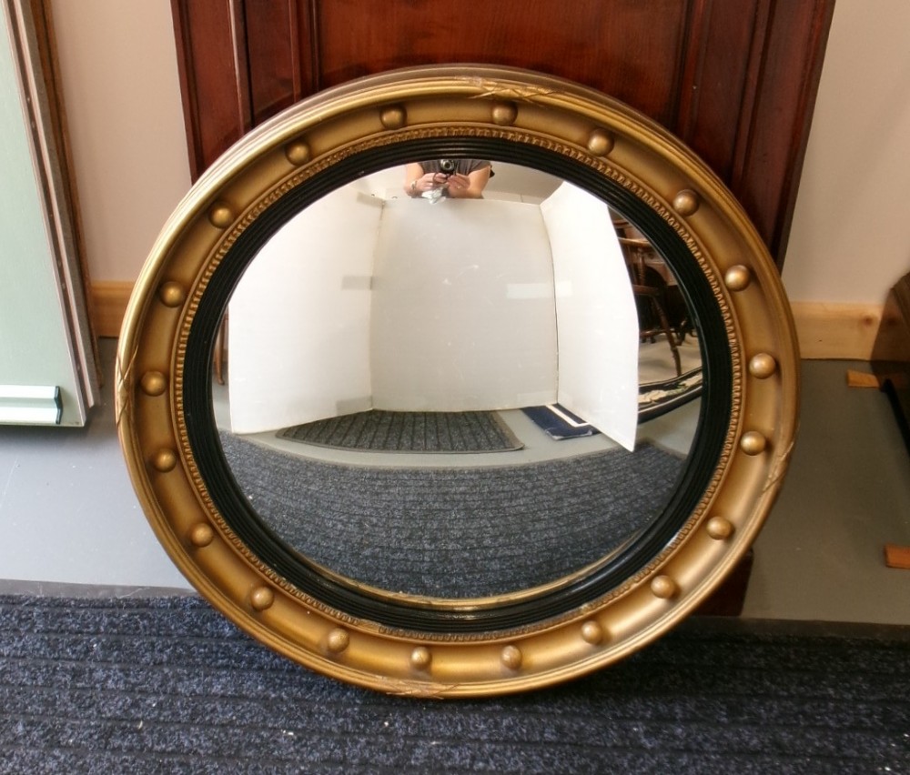 A circular Victorian giltwood convex mirror featuring a ball-decorated outer frame and a black ebonised inner slip. View X