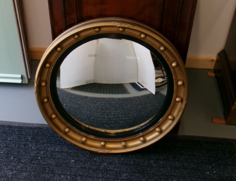 A circular Victorian giltwood convex mirror featuring a ball-decorated outer frame and a black ebonised inner slip. View XI