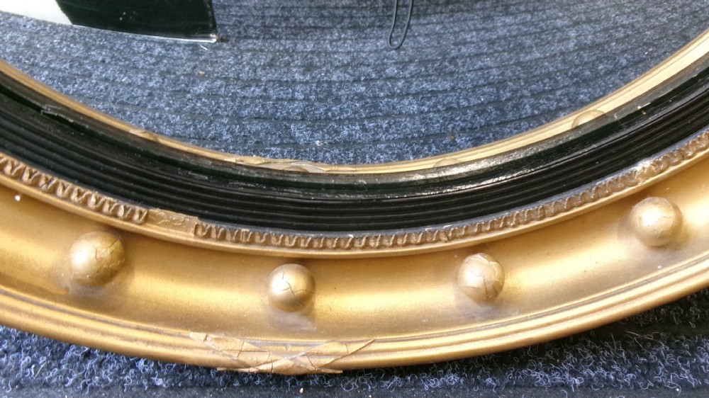 A circular Victorian giltwood convex mirror featuring a ball-decorated outer frame and a black ebonised inner slip. View XIII