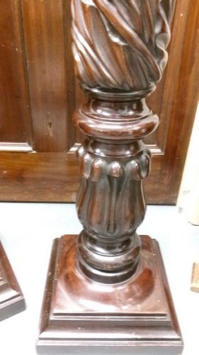 A pair of tall Victorian dark mahogany torchere stands featuring circular dished tops, spiral acanthus leaf carved shafts, and square plinth bases. View II