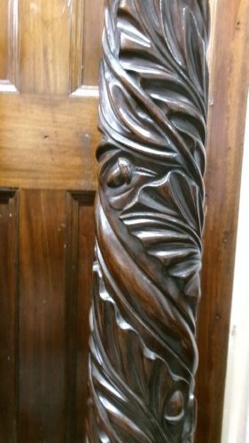 A pair of tall Victorian dark mahogany torchere stands featuring circular dished tops, spiral acanthus leaf carved shafts, and square plinth bases. View III