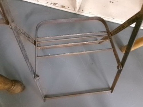 A miniature vintage clothes mangle crafted with a grey iron frame, wooden rollers, a hand crank, an attached galvanised metal tub, and a wooden laundry posser. View IX