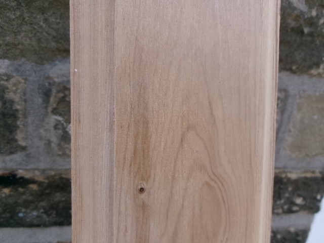 A long vertical pine wood backboard fitted with four double-pronged brass coat hooks. View XI