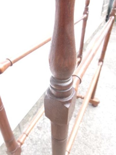 A freestanding Victorian mahogany towel rail featuring arched side supports, turned upright spindles, and four horizontal crossbars. View II