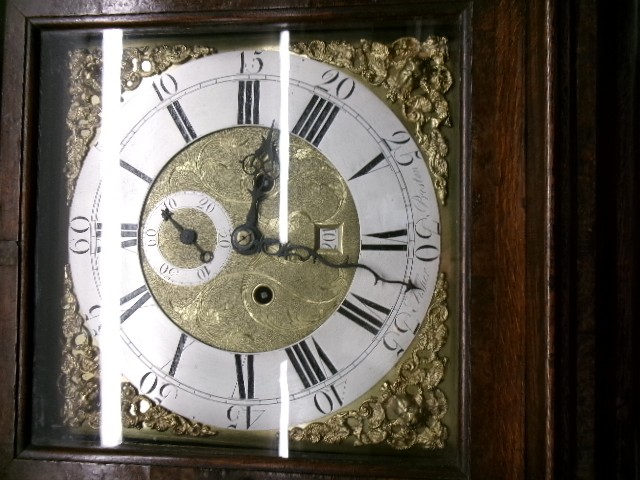 An 18th-century Georgian dark oak longcase clock featuring a square brass dial, fluted hood columns, and a moulded base. View II