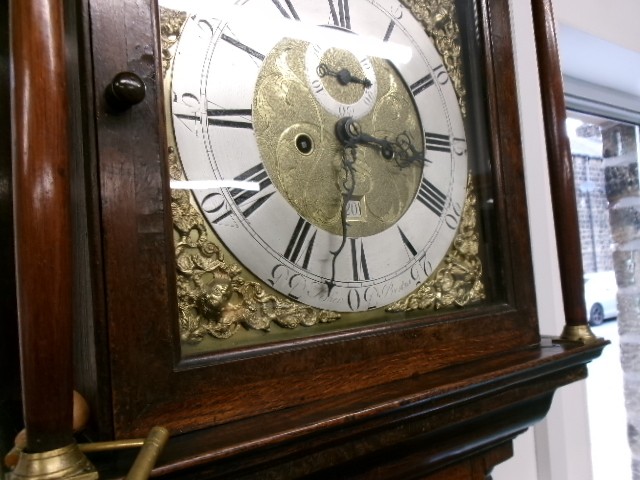 An 18th-century Georgian dark oak longcase clock featuring a square brass dial, fluted hood columns, and a moulded base. View III