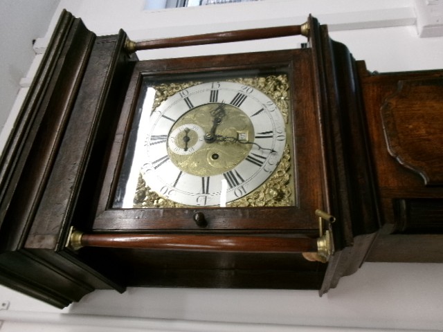 An 18th-century Georgian dark oak longcase clock featuring a square brass dial, fluted hood columns, and a moulded base. View VII