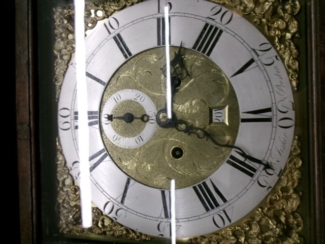 An 18th-century Georgian dark oak longcase clock featuring a square brass dial, fluted hood columns, and a moulded base. View X