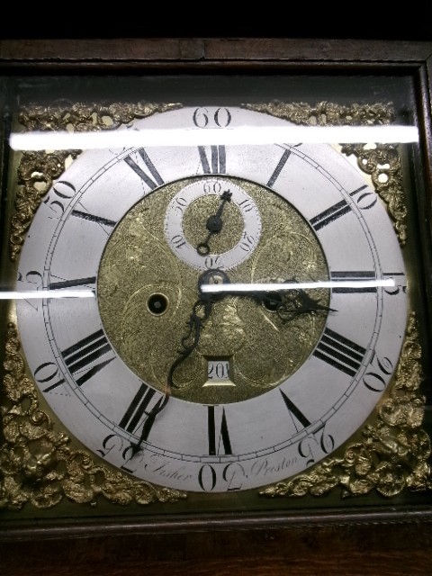 An 18th-century Georgian dark oak longcase clock featuring a square brass dial, fluted hood columns, and a moulded base. View XI