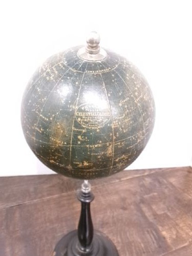 A 1930s celestial globe with a dark green sphere depicting printed constellations, supported on a turned ebonised black wooden stand with a metal axis. View II