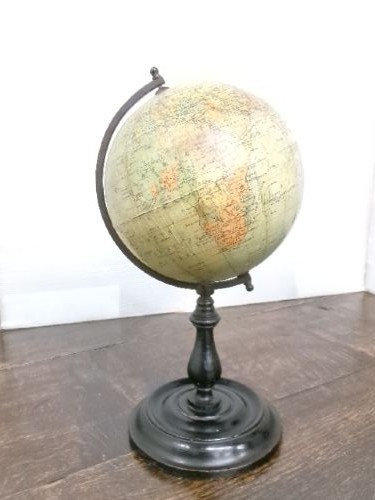 A small 1930s Philips terrestrial globe with printed paper map gores mounted on a dark turned metal and wooden stand. View IV