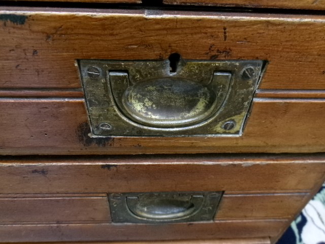 A pine military campaign chest featuring flush recessed brass handles and multiple small drawers. View XII