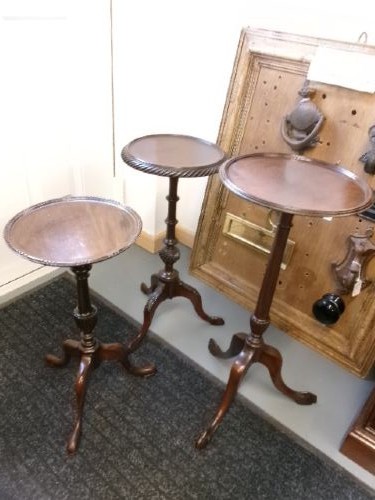 A trio of Edwardian mahogany wine tables featuring turned central pedestals, dished circular tops, and carved tripod cabriole legs. View IV
