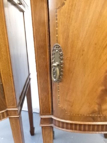 A pair of Edwardian mahogany bedside cabinets featuring bow fronts, satinwood string inlay, shaped upstands, and tapered legs. View X