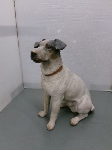 A Victorian painted terracotta figure depicting a seated Jack Russell terrier with grey ears and a brown painted collar.