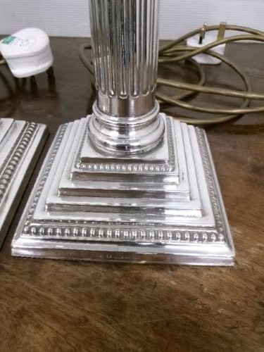 A pair of silver-plated table lamps designed as fluted Corinthian columns set upon square stepped bases. View V