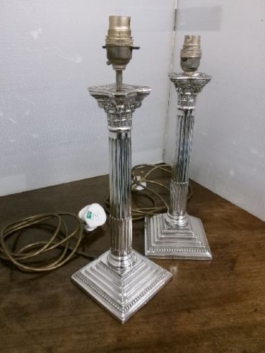 A pair of silver-plated table lamps designed as fluted Corinthian columns set upon square stepped bases. View IX