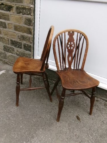 A pair of traditional wooden Windsor chairs featuring contoured elm seats, pierced wheelback splats, hoop backs, and turned legs connected by H-stretchers. View III