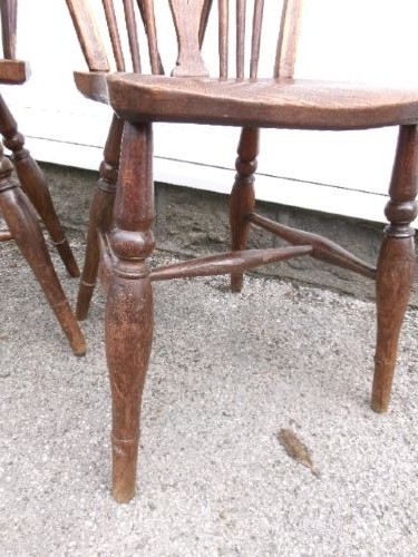 A pair of traditional wooden Windsor chairs featuring contoured elm seats, pierced wheelback splats, hoop backs, and turned legs connected by H-stretchers. View IV