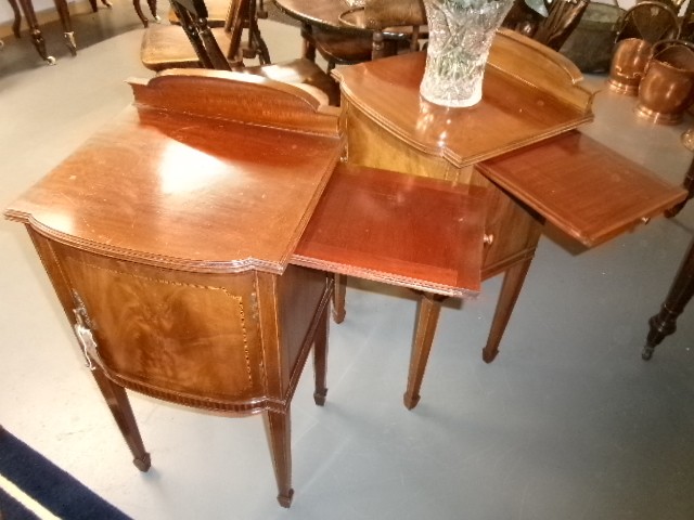 A pair of Edwardian mahogany bedside cabinets featuring bow fronts, satinwood string inlay, shaped upstands, and tapered legs. View XII