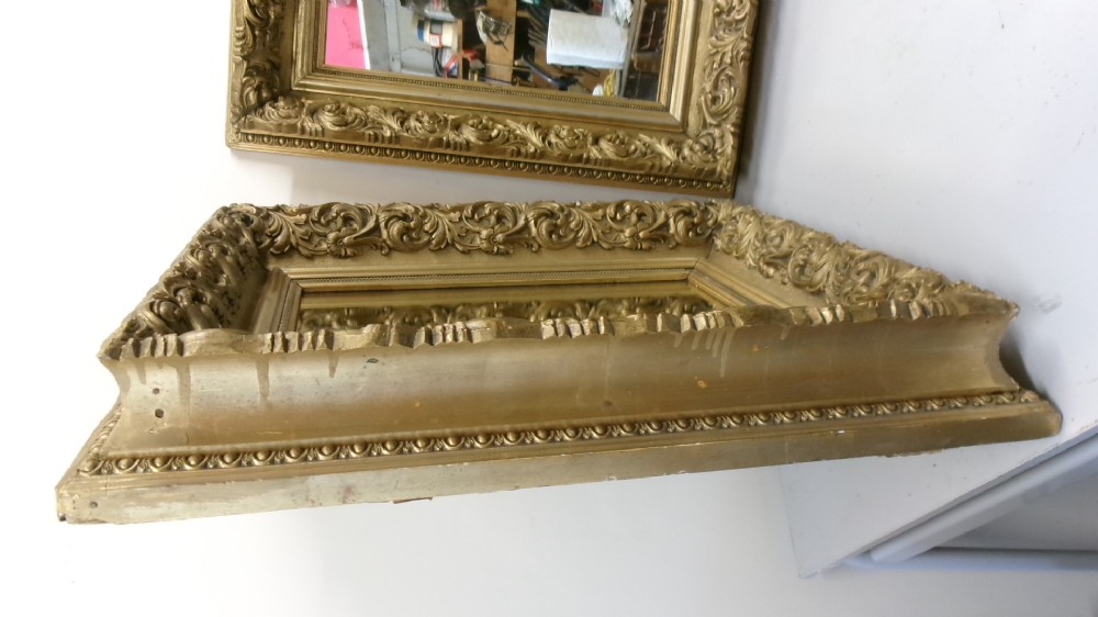 A matching pair of rectangular wall mirrors featuring deeply carved gold gilt frames with ornate scrollwork and moulding. View VII