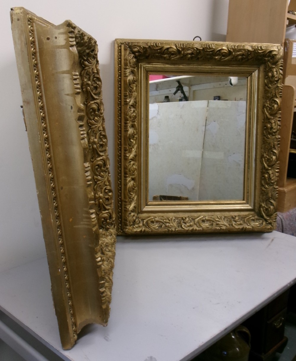 A matching pair of rectangular wall mirrors featuring deeply carved gold gilt frames with ornate scrollwork and moulding. View VIII