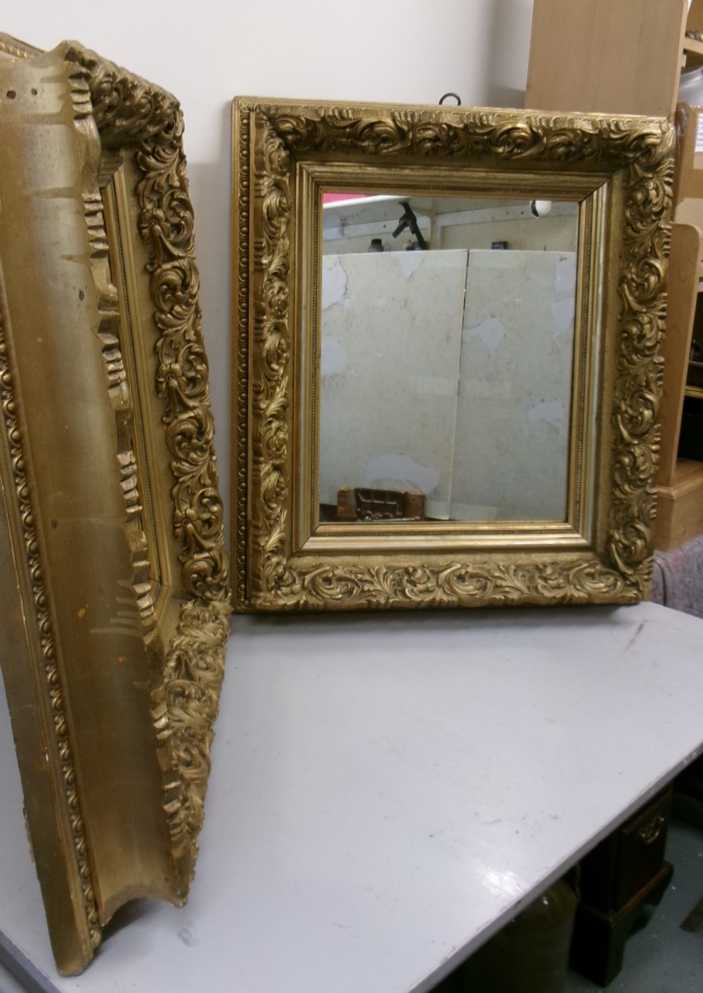 A matching pair of rectangular wall mirrors featuring deeply carved gold gilt frames with ornate scrollwork and moulding. View IX