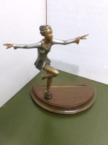 An Art Deco spelter figure of a dancing female posing dynamically in front of a circular bevelled glass mirror set on a wooden plinth base. View VI