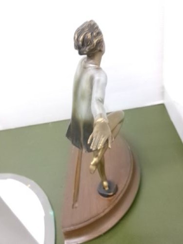 An Art Deco spelter figure of a dancing female posing dynamically in front of a circular bevelled glass mirror set on a wooden plinth base. View XI