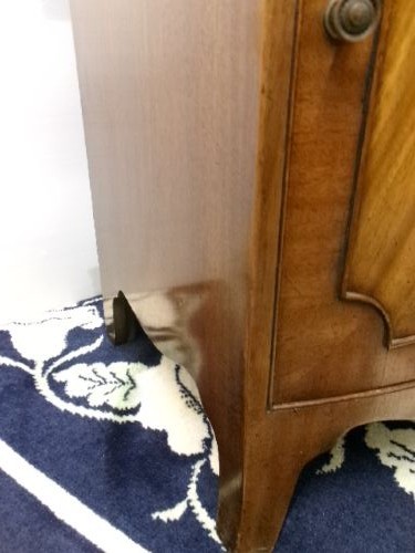 An Edwardian bow-front mahogany cabinet featuring two upper drawers with brass knobs over a panelled cupboard door. View VIII