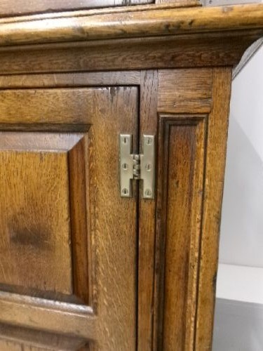 A large two-section warm brown oak bookcase featuring two upper glazed doors with internal shelves above two lower field-panelled wooden doors. View IX