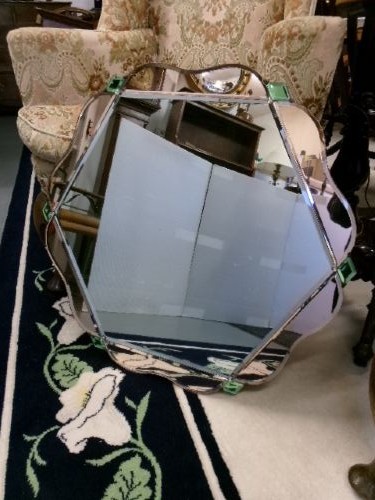 An Art Deco frameless wall mirror featuring peach-tinted geometric border panels, green corner clips, and a scalloped edge silhouette. View VIII