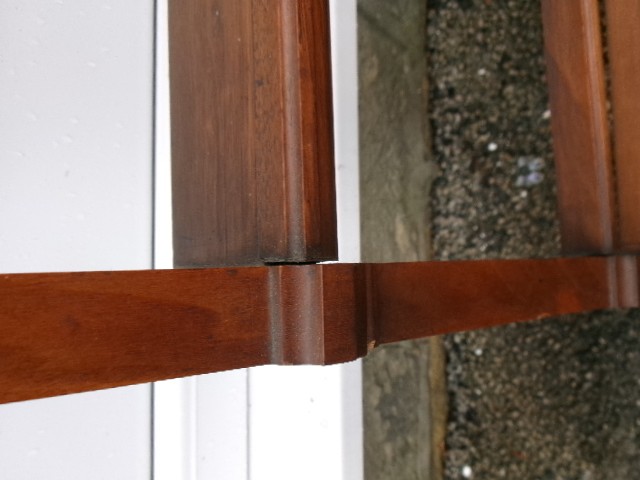 A mahogany wall-hanging rack featuring a top shelf, open tiers with horizontal retaining bars, shaped side brackets, and top brass mounting rings. View VIII