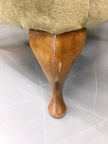 A high-backed Georgian style wing armchair upholstered in textured olive green fabric with dark wooden legs. View VII