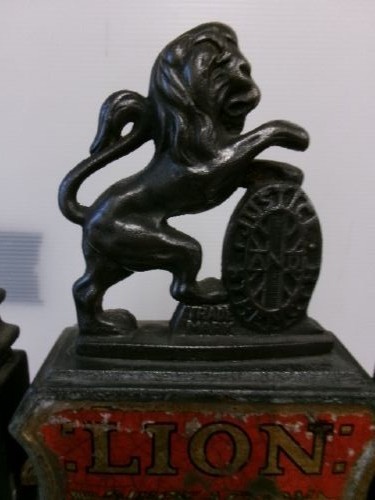 A Victorian cast iron and brass commercial weighing scale featuring a top lion crest, brass pan, and ceramic platform. View VI