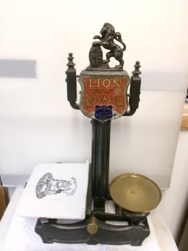 A Victorian cast iron and brass commercial weighing scale featuring a top lion crest, brass pan, and ceramic platform. View XIII
